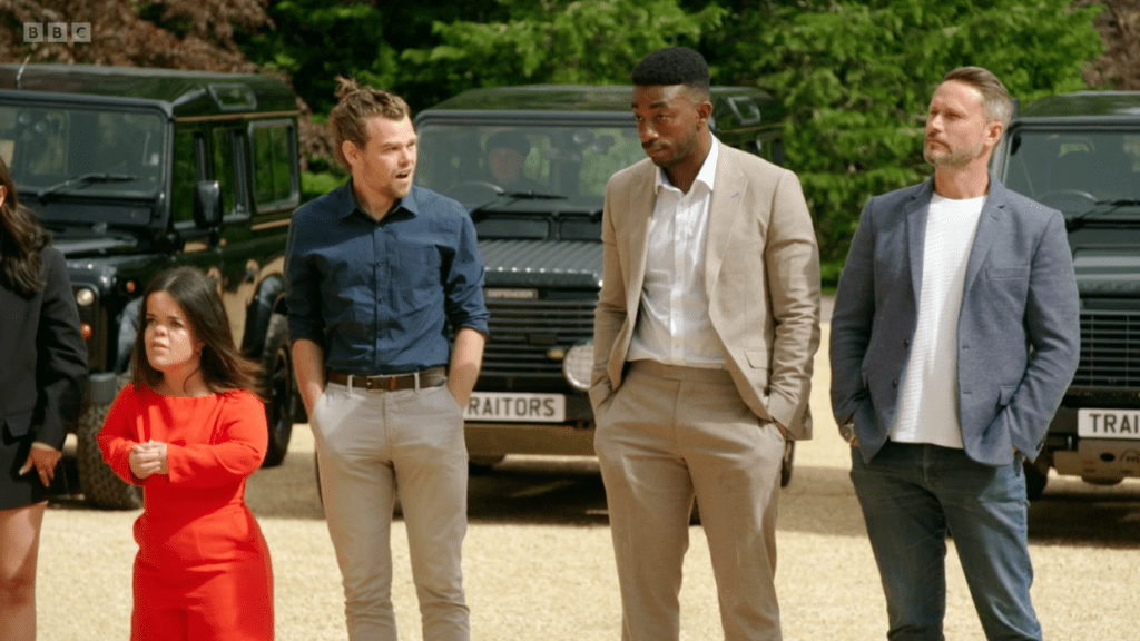 Ivan turns to look at fellow contestants Amos and Kieran with a look of shock on his face during episode one of The Traitors